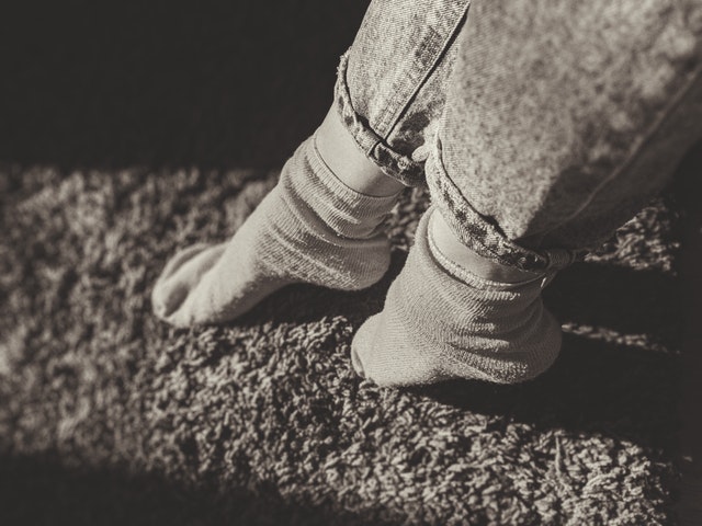 nohy na koberci v šedé barvě